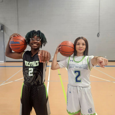 Two Empower College Prep scholars in basketball uniforms