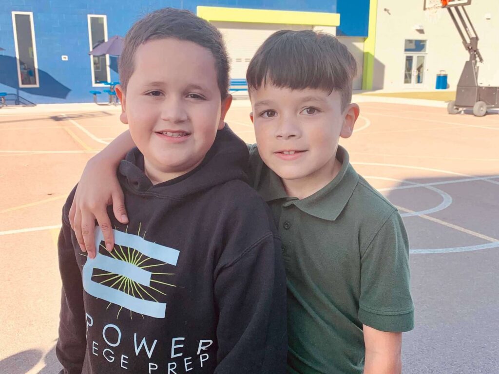 Empower College Prep elementary school male students stand together on the school’s playground and pose for the camera.