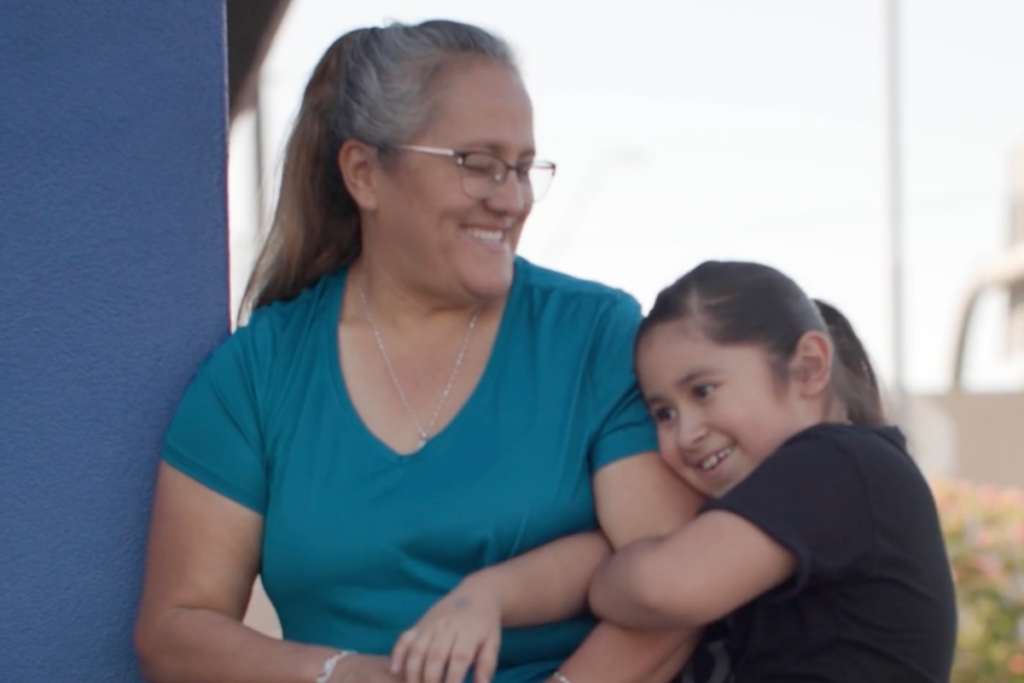 An Empower College Prep scholar hugs her mother on the ECP campus. 