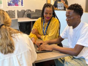 Male Empower College Prep student sits at his desk in a classroom and  works side by side with a teacher.