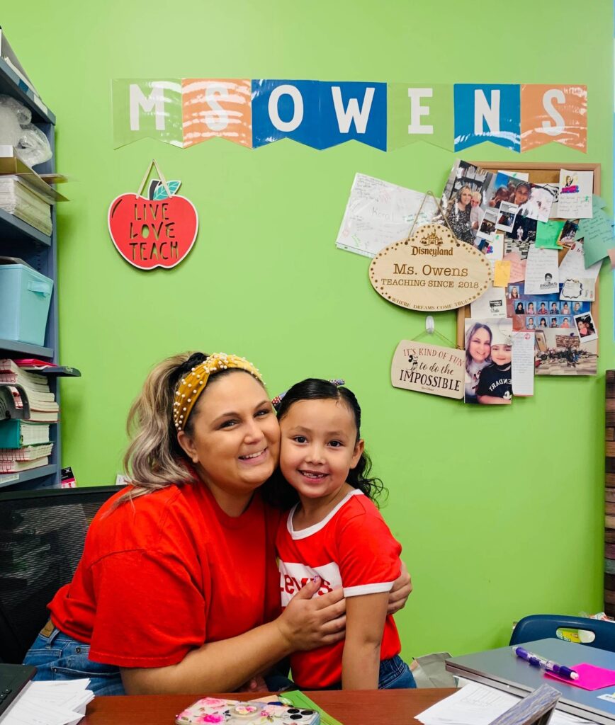 An Empower College Prep teacher hugs one of her students in their classroom.