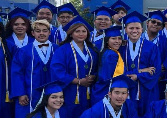 Empower College Prep seniors pose together in their graduation regalia as they prepare to receive their diplomas.