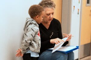 An Empower College Prep Kindergartener reviews school work with a teacher. 