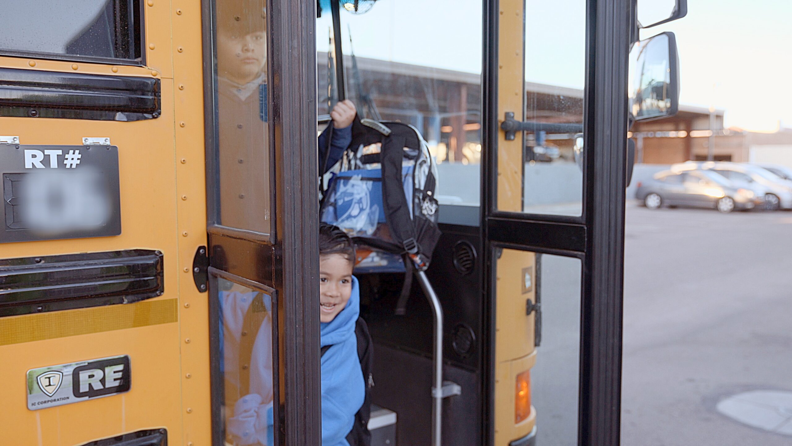 A young Empower College Prep student steps off the school bus arriving at school.