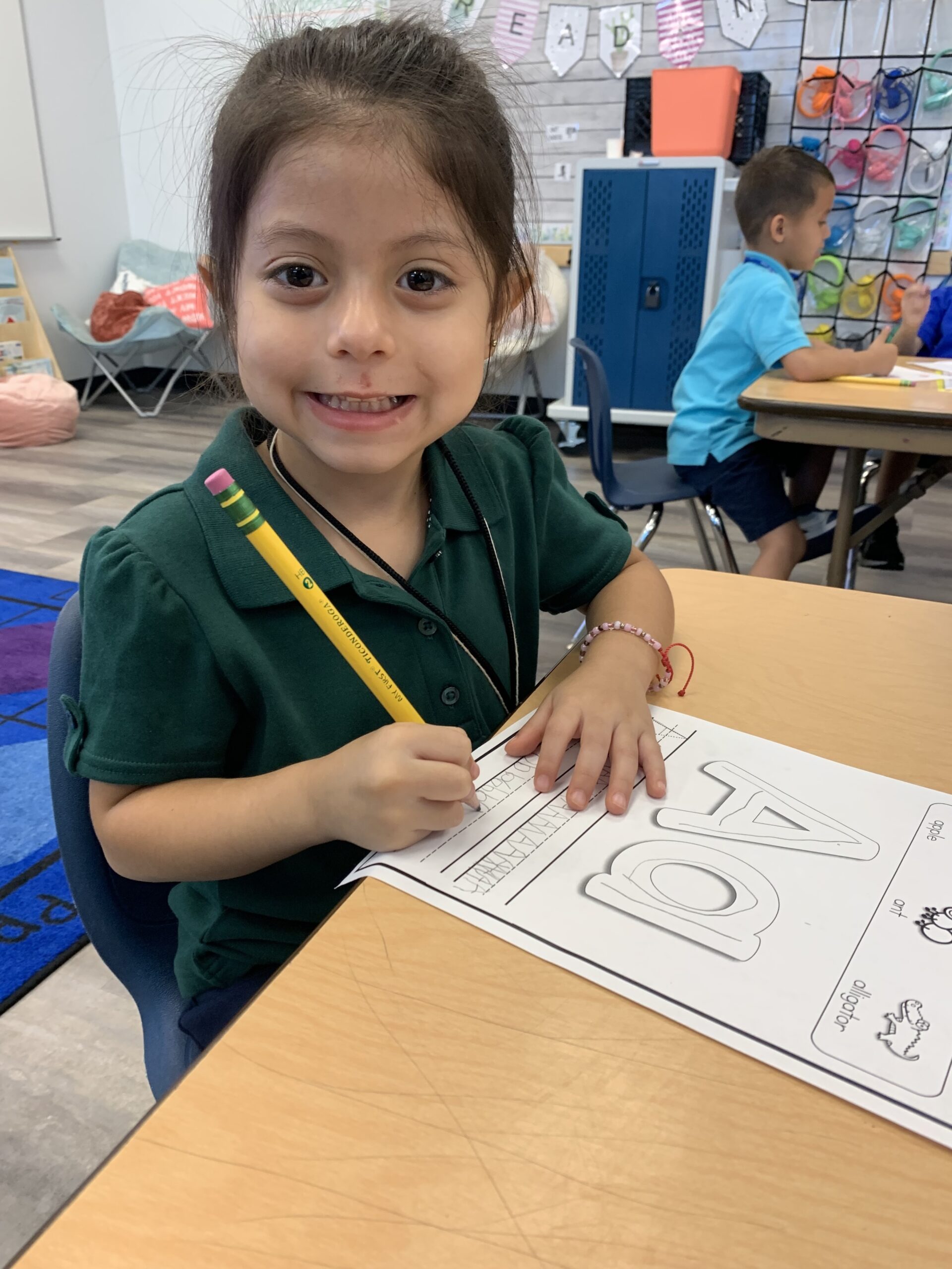 An Empower College Prep female elementary student works on an alphabet worksheet.