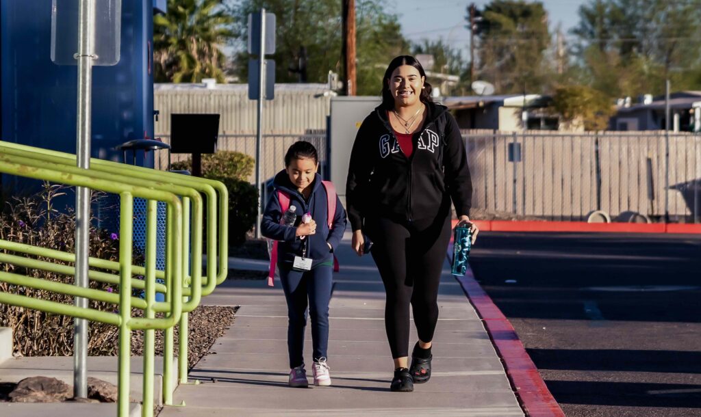 An Empower College Prep female elementary student walks with her mother on the school campus.